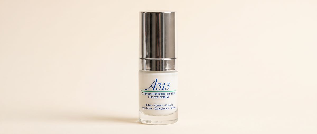Close-up of the A313 Eye Serum bottle and cap in soft daylight on a wide, clean background