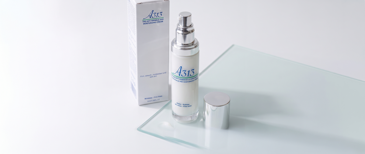 Flacon pompe de la crème A313 Anti-Wrinkle and Moisturizing Cream à côté d'une noisette de crème sur une surface en verre clair, à la lumière douce du jour